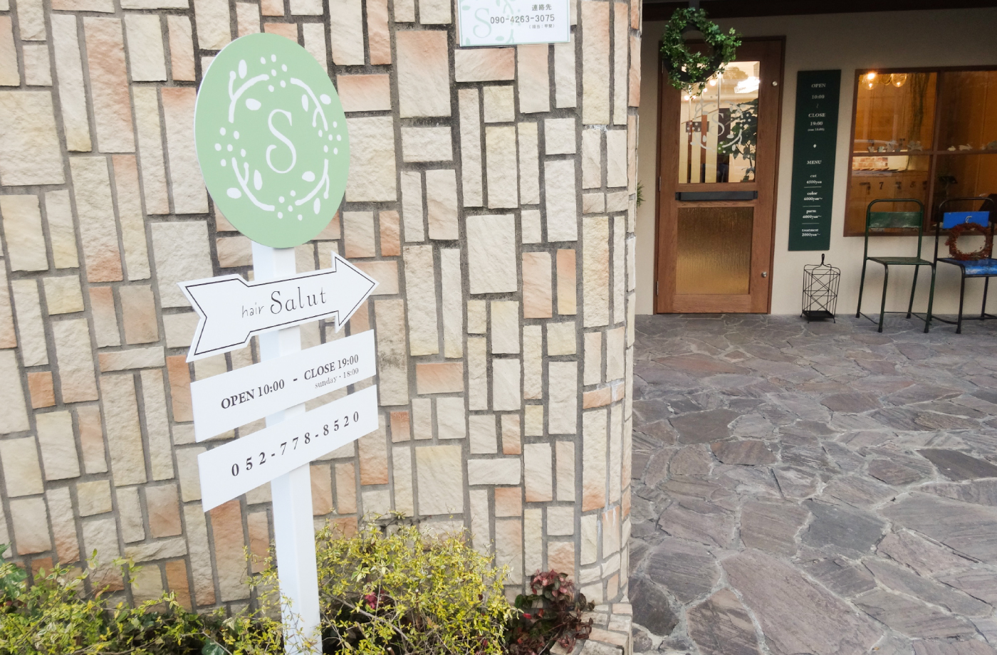 植え込みにあるロゴと営業時間が記載された自立看板